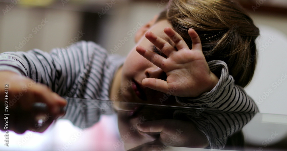 Sad small boy covering face with hand feeling sad and depressed Sad small boy covering face with hand feeling sad and depressed