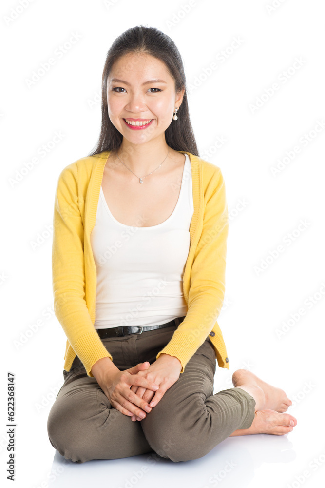 Full length casual Asian girl sitting on floor smiling and looking at camera, isolated on white background. Full length casual Asian girl sitting on floor smiling and looking at camera, isolated on white background.