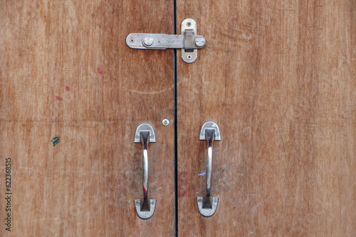 The front door is a large plank with metal handles.