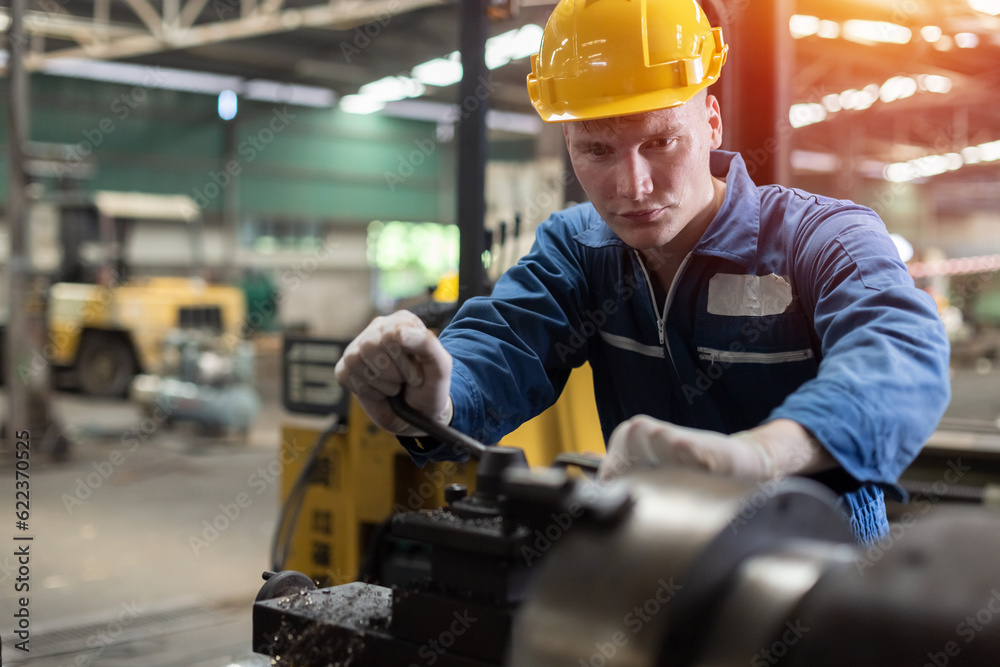 Caucasian man engineering workers wear yellow hard hat working machine lathe metal in factory industrial. mechanical operator male worker. Heavy industry concept. Caucasian man engineering workers wear yellow hard hat working machine lathe metal in factory industrial. mechanical operator male worker. Heavy industry concept.