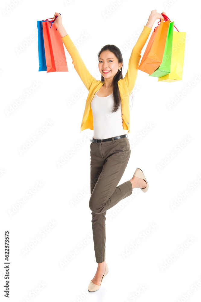 Happy young Asian girl shopper, hands outstretched holding shopping bags and smiling, full length isolated standing on white background. Happy young Asian girl shopper, hands outstretched holding shopping bags and smiling, full length isolated standing on white background.