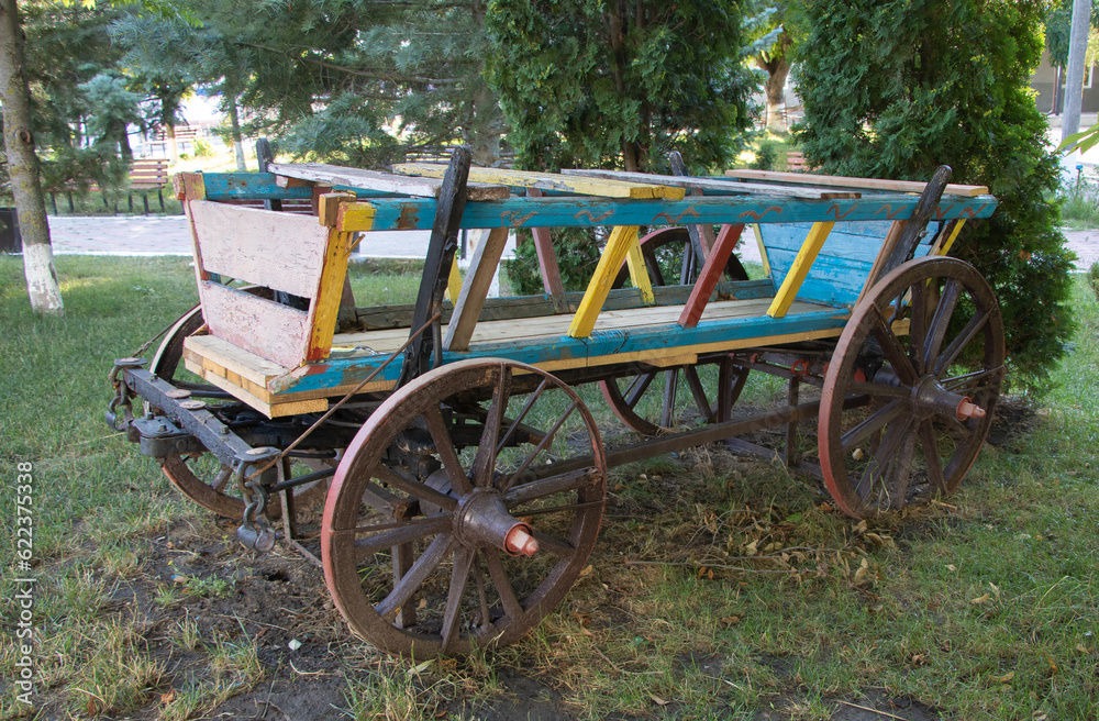 Old wooden cart in the park, close-up of photo