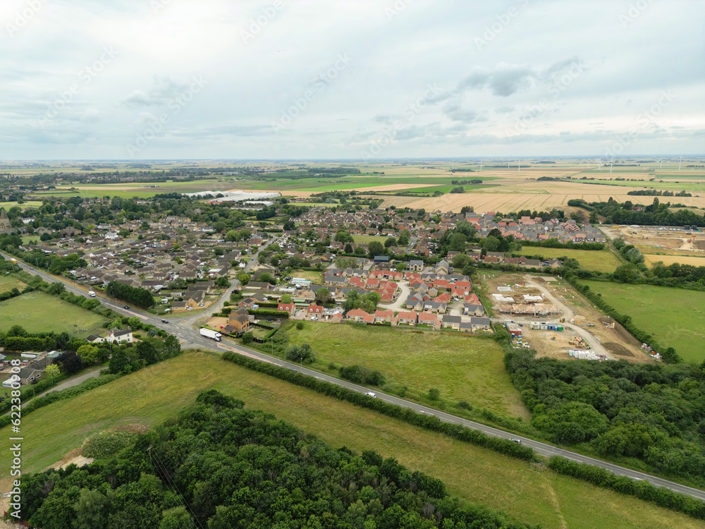 Drone high altitude view of a typical English village showing a large expansion of houses to the right of the image.