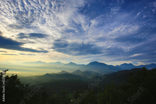 Sunrise landscape with continuous mountains and colorful sky clouds