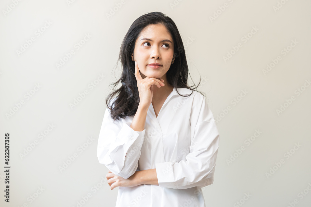 Portrait of positive thoughtful asian young woman, girl keeps hand on chin looking away in white shirt casual, adult female thinking creative, thinks about future person, isolated on white background. Portrait of positive thoughtful asian young woman, girl keeps hand on chin looking away in white shirt casual, adult female thinking creative, thinks about future person, isolated on white background.