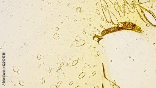 Transparent cosmetic gel fluid with molecule bubbles oil distribution on a white background. Macro Shot of Natural Organic Cosmetics, Medicine. Production Close-up. Slow Motion. High quality 4k