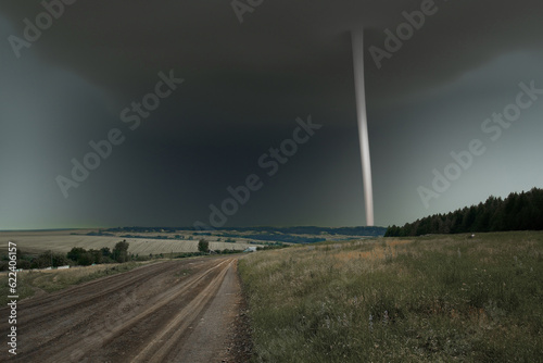 Rural landscape with tornado beyond.