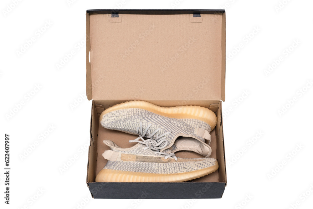 Light sneakers made of fabric with ventilation in a cardboard box on a white background, isolated