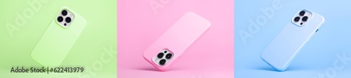set of three smart phones in pink blue and green silicone case falling down in different angles, back view isolated on background, phone case mockup in monochrome colours for iPhone 15 pro