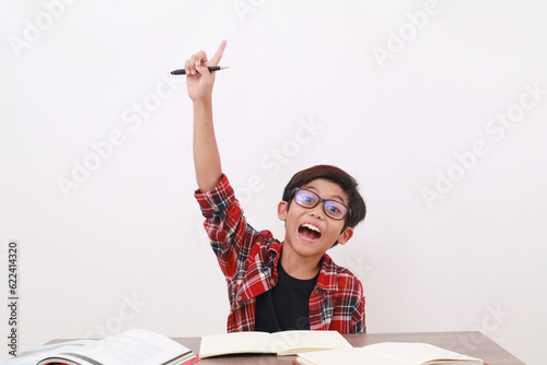 Excited asian student raising his hand while studying. Isolated on white background