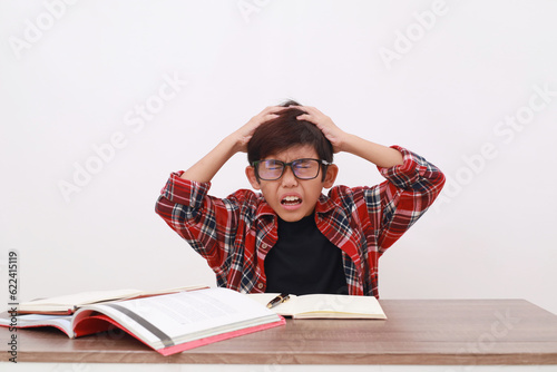 Obraz na plátne Stressed asian student holding his head, suffering from headache