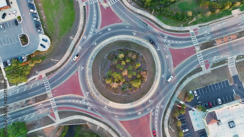 View from above of roundabout crossroads on american city street with moving traffic cars. Urban circular transportation crossroads View from above of roundabout crossroads on american city street with moving traffic cars. Urban circular transportation crossroads