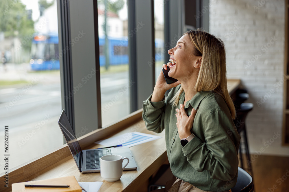 Smiling woman manager is talking phone in coworking during work on laptop. Distance work concept Smiling woman manager is talking phone in coworking during work on laptop. Distance work concept