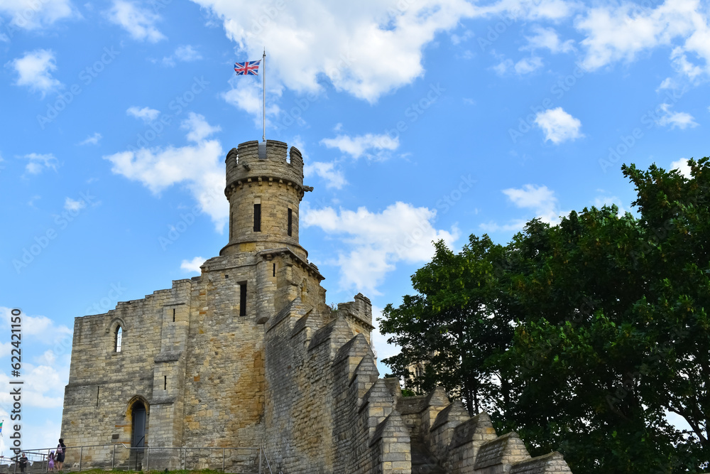 castle tower and walls ruins with english flag and blue skies