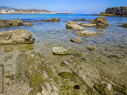 Movement and reflection of transparent water with rocks in the mediterranean sea next to Isla Las Palomas and with Punta del Santo in the background, Tarifa SPAIN photo