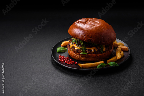 Burger with juicy beef cutlet, cheese, tomatoes, salt, spices and herbs