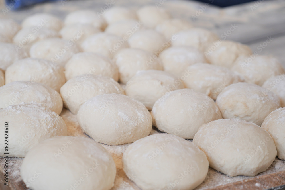  fresh raw dough for bread or pizza .