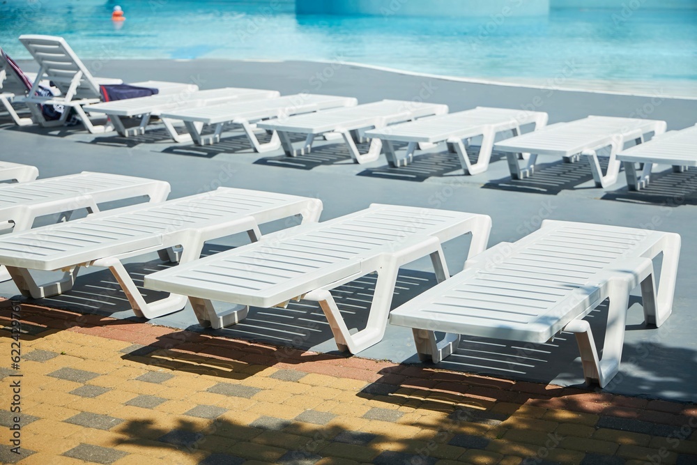 Beach chairs by the pool in the hotel or spa. Recreation and entertainment for the summer.