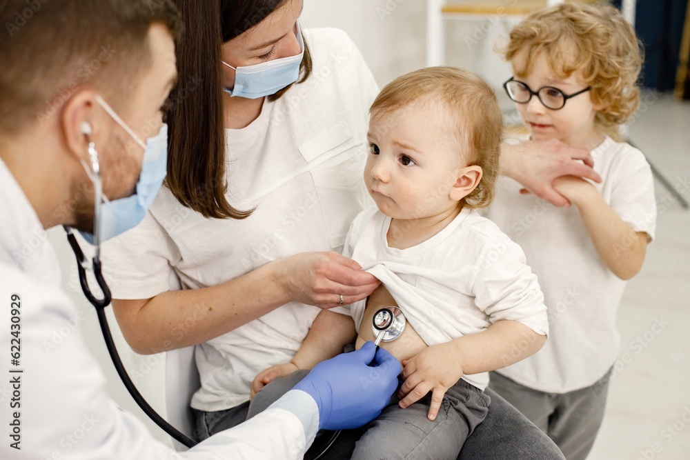 Mother and two her sons have an appointment with pediatrician Mother and two her sons have an appointment with pediatrician