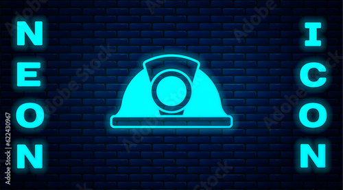 Glowing neon Miner helmet icon isolated on brick wall background. Vector