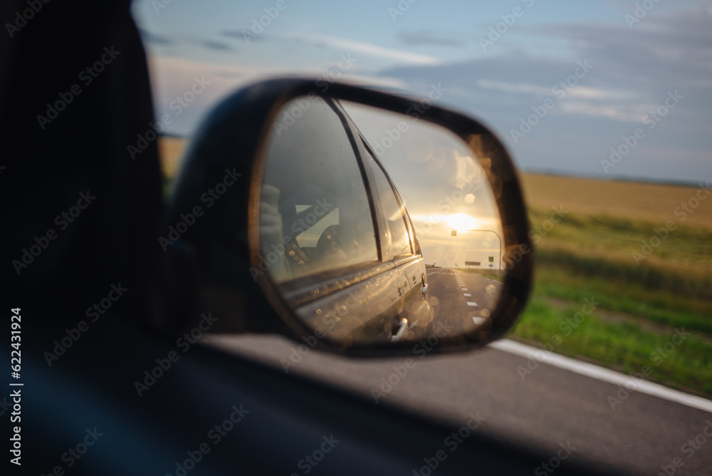 The car mirror with the reflection of the setting sun The car mirror with the reflection of the setting sun
