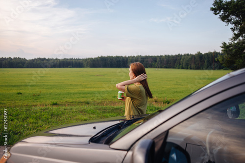 The girl travels by car, rests near the car and admires nature