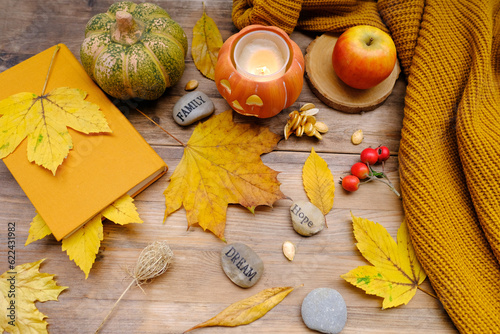 Autumn composition on rustic wooden table in garden with fallen yellow, orange leaves and berries, concept happy Thanksgiving day, hello autumn, nature protection, good weather, cozy autumn mood