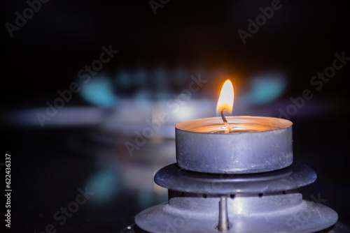 A small candle on the background of a flame from a gas burner