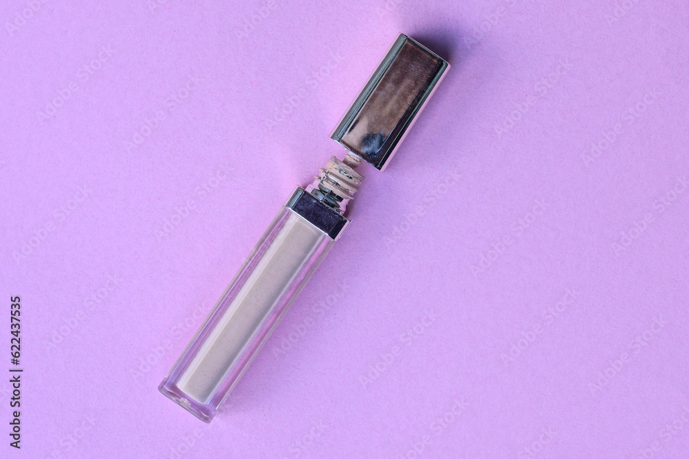 cosmetics from a brown plastic tube with mascara and a brush lies on a pink table cosmetics from a brown plastic tube with mascara and a brush lies on a pink table