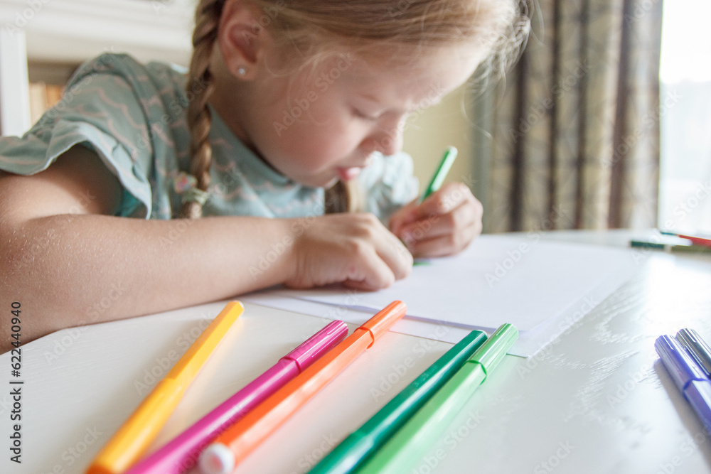 Cute child drawing a picture with colored felt-tip pens. Concept of hobby Cute child drawing a picture with colored felt-tip pens. Concept of hobby