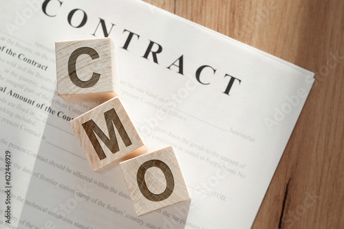 CMO Chief Marketing Officer written on a wooden cube on the contract photo