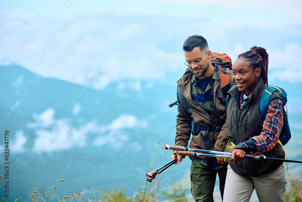Young couple enjoys in walk while hiking on mountain.