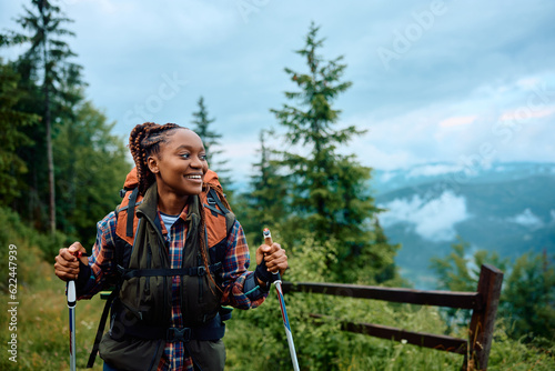 Happy black female hiker enjoys in walk in mountains.