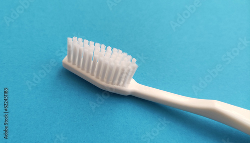 White toothbrush isolated on blue background