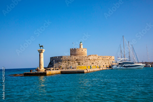 Landscape with Mandraki Harbour and two statues, Elefos and Elafina in Rhodes Island, Greece photo