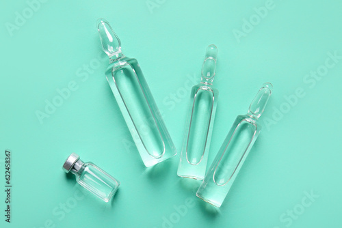 Medical ampules on green background