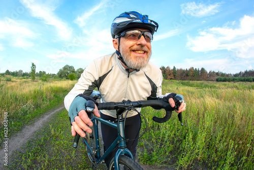 bearded man cyclist rides a bike on a road in nature. sports, hobbies and entertainment for health