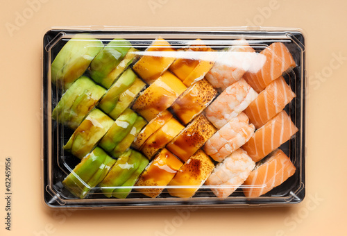 Set of sushi rolls in plastic packages on a light background, top view.