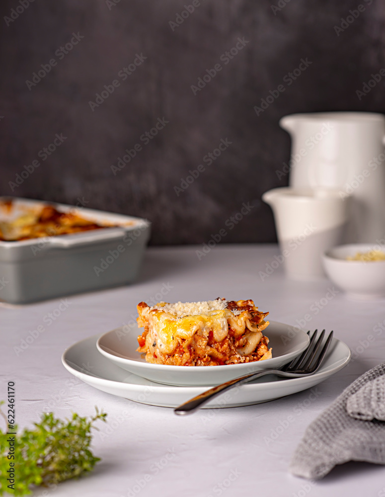 Food photography of lasagna, quiche, casserole, cheese, tomato sauce, parmesan, plate, towel, stand, ground rustic, italian food, pasta, bolognese