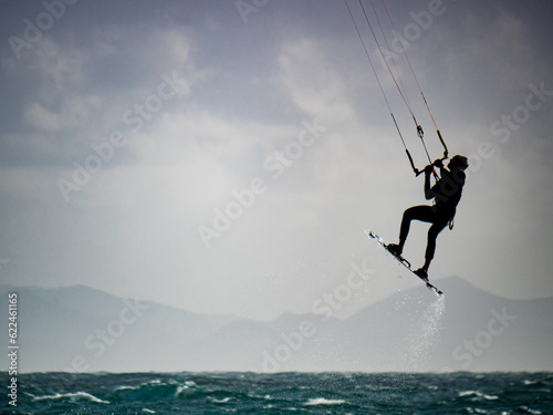 Kite surfer riding waves. Kiteboarding sport.