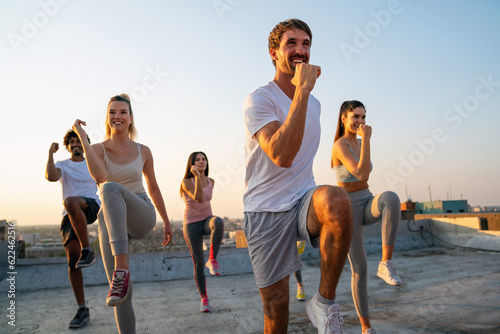 Group of fit healthy friends, people exercising together outdoor