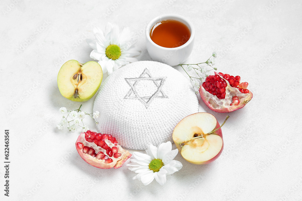 Composition with kippah, ripe fruits, flowers and honey on light background. Rosh hashanah (Jewish New Year) celebration