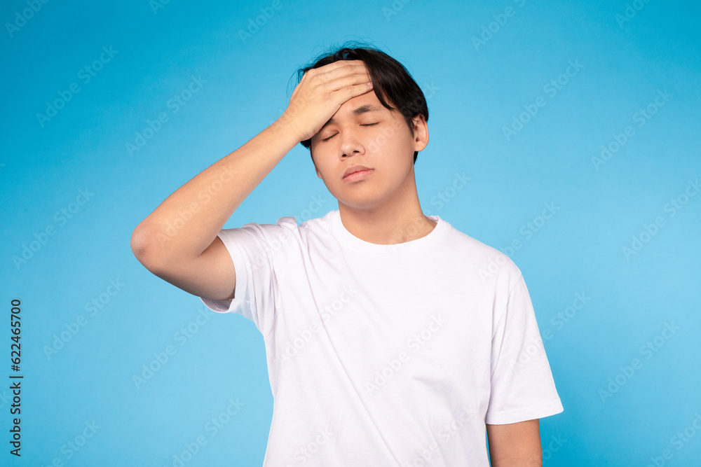 Korean Guy Feeling Unwell Touching Forehead Having Fever, Blue Background Korean Guy Feeling Unwell Touching Forehead Having Fever, Blue Background