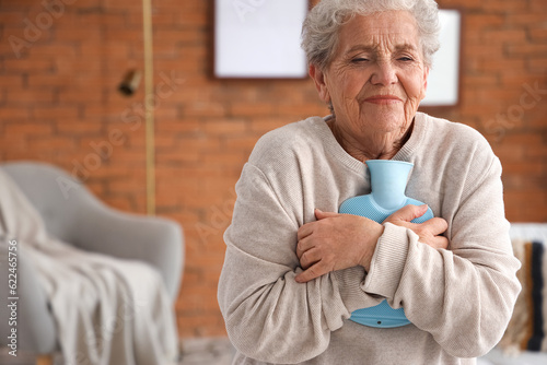 Canvastavla Ill senior woman with hot water bottle at home