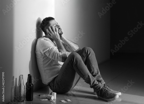 Male junkie with drugs sitt...