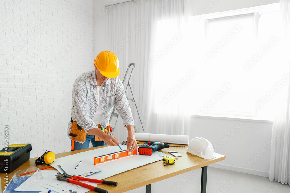 Mature builder working at table in room Mature builder working at table in room