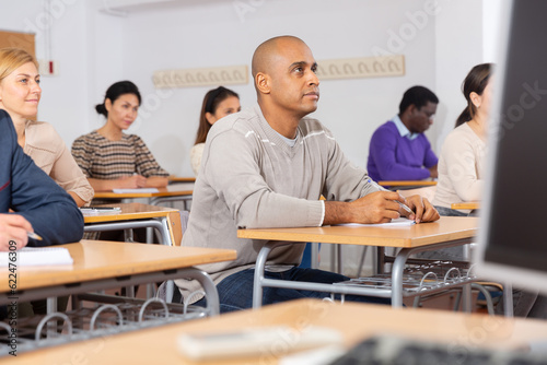 Portrait of confident man sitting in class working during group business training
