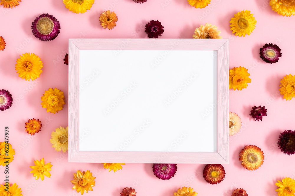 Floral background with beautiful flowers. Flat lay, top view of photo frame and flowers on pastel pink background. Floral background with beautiful flowers. Flat lay, top view of photo frame and flowers on pastel pink background.