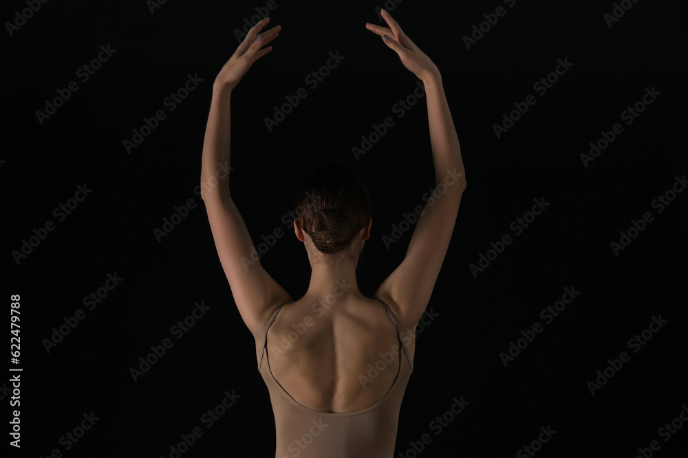 Young ballerina dancing on black background, back view - obrazy, fototapety, plakaty 
