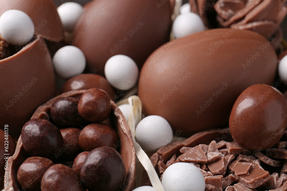 Tasty chocolate eggs and sweets as background, closeup